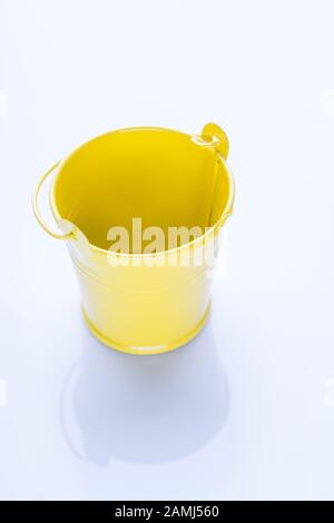 Secchio giallo vuoto isolato su bianco. Foto Stock