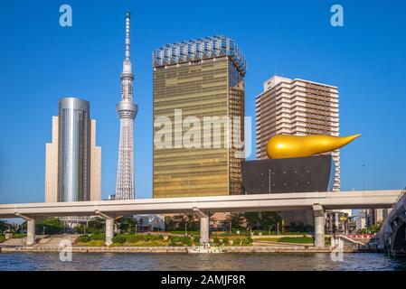 Tokyo, Giappone - 13 giugno 2019: Asahi Beer Hall, progettata dal designer francese Philippe Starck e completata nel 1989, sulla riva del fiume Sumida con tok Foto Stock