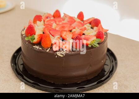 Deliziosa torta al cioccolato con molte fragole a fette. Concetto Di Festa. Messa a fuoco selettiva. Foto Stock