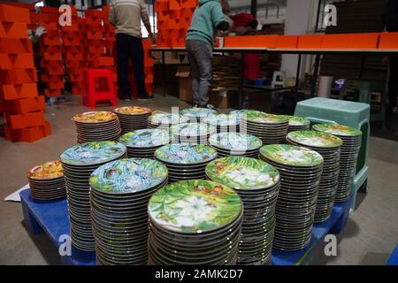 (200114) -- JINGDEZHEN, 14 gennaio 2020 (Xinhua) -- un operaio impacca piatti di ceramica progettati da Wu Anran con l'anno cinese del Rat a Jingdezhen, provincia di Jiangxi della Cina orientale, 9 gennaio 2020. Jingdezhen, conosciuta anche come la "capitale delle Porcellane", è famosa per la sua elaborata lavorazione ceramica che richiede un processo di produzione estremamente complicato. In passato, molti giovani, competenti e ambiziosi progettisti di porcellana potevano creare buoni disegni ma avevano difficoltà a completare in modo indipendente la produzione e le vendite. D'altra parte, le imprese tradizionali che potrebbero fare la produzione e. Foto Stock