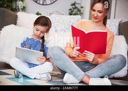 Mamma e bambino concentrati che studiano con la tecnologia Foto Stock