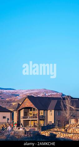 Case Verticali Distanti contro le colline coperte di neve luce di giorno Foto Stock