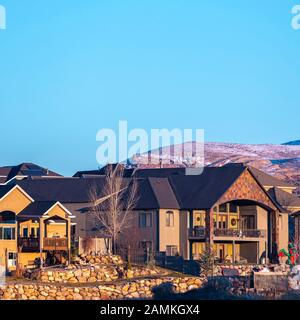 Case a Distanza quadrata contro le colline coperte di neve giorno luce Foto Stock