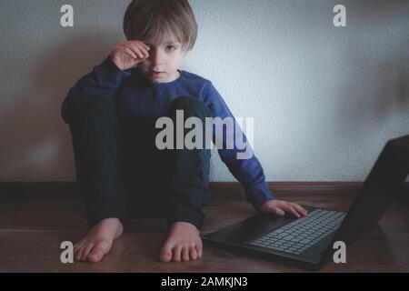 Concetto di bullismo cibernetico - ragazzo depresso con blocco note e commenti negativi Foto Stock