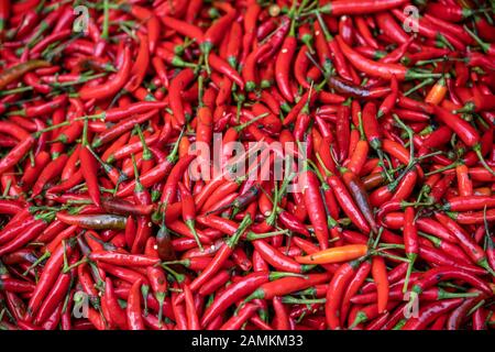 Chilis caldo rosso per la vendita immagazzinato in un grande arco tondo di vimini su un mercato di strada in Cina Foto Stock
