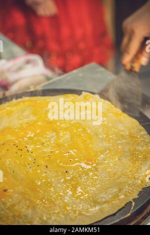 Donna che fa frittelle saporite dell'uovo in una panetteria locale di uscita della strada nella città di Yichang, Cina Foto Stock