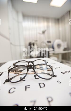 Immagine di fondo degli occhiali sulla carta degli occhi in ufficio oftalmologia, visione e concetto di test degli occhi, copia spazio Foto Stock
