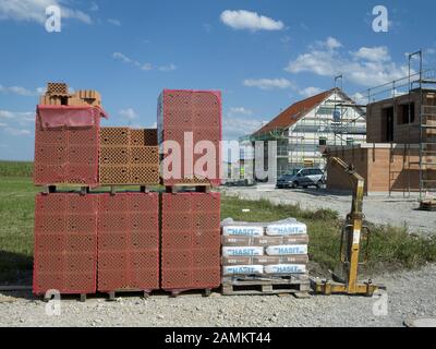 Pila di mattoni da costruzione nella nuova area di sviluppo nella zona industriale occidentale di Maisach. [traduzione automatizzata] Foto Stock