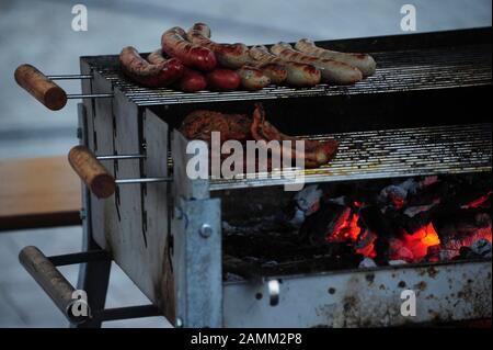 Standgrill con salsicce sulla griglia sulle rive dell'Isar a Monaco. [traduzione automatizzata] Foto Stock