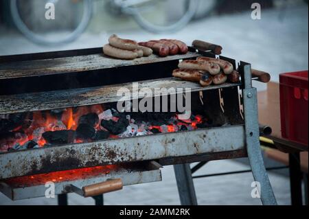 Standgrill con salsicce sulla griglia sulle rive dell'Isar a Monaco. [traduzione automatizzata] Foto Stock