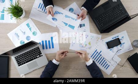 I manager controllano i diagrammi di business, discutono il rapporto finanziario, il brainstorming Foto Stock