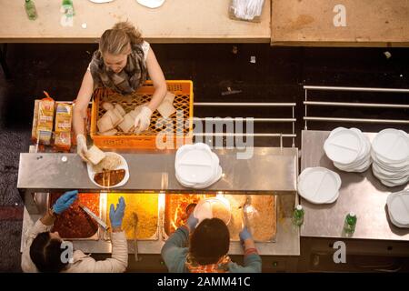 Improvvisato alloggio temporaneo per i rifugiati in una sala espositiva a Riem: La foto mostra la distribuzione alimentare per le persone stanche e affamate. [traduzione automatizzata] Foto Stock