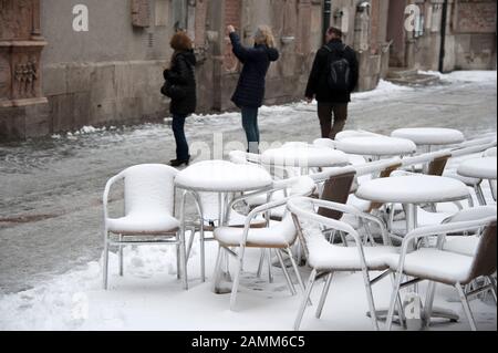 I mobili di una caffetteria di strada all'Alter Peter sono spesso intarciati in una fredda giornata di marzo. Turisti che scattano foto sullo sfondo. [traduzione automatizzata] Foto Stock