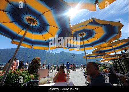 Ombrelloni in un ristorante nel villaggio di pescatori Limone sul Garda sul Lago di Garda. [traduzione automatizzata] Foto Stock