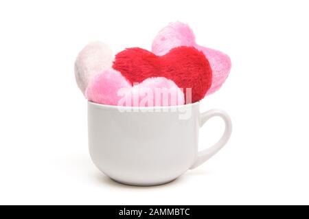 Carta bianca comune e nuova tazza da caffè traboccante di rosso fuzzy e Cuori rosa Foto Stock