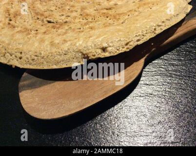 Pane piatto di injera fatto da farina di teff. Teff, chiamato anche mulino nano, appartiene alla famiglia dell'erba dolce. La gamma naturale è in Etiopia ed Eritrea, ma la specie è coltivata anche in altre zone tropicali e subtropicali. I semi sono privi di glutine e ricchi di acidi grassi essenziali. Questo tipo di miglio è il grano più importante in Etiopia. Viene trasformato in pane e birra piatti o viene utilizzato anche come mangime per animali [traduzione automatizzata] Foto Stock