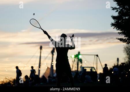 I visitatori di Tollwood giocano a badminton nel Parco Olimpico in una serata estiva. [traduzione automatizzata] Foto Stock