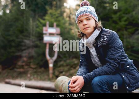 Ragazzo adolescente nella foresta d'autunno Foto Stock