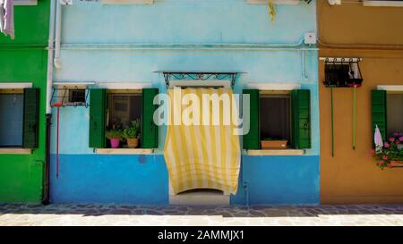 Bella casa blu in strada multicolore dell'isola di Burano, accogliente casa italiana Foto Stock