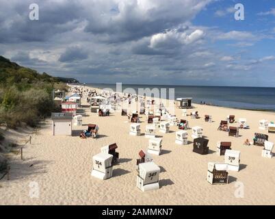 Vista dal ponte sul mare Heringsdorf sulla spiaggia sabbiosa del Mar Baltico con molte sedie a sdraio in condizioni di sole e la suggestiva atmosfera nube sull'isola Usedom nel Mecklenburg Vorpommern, Germania, Europa. [traduzione automatizzata] Foto Stock