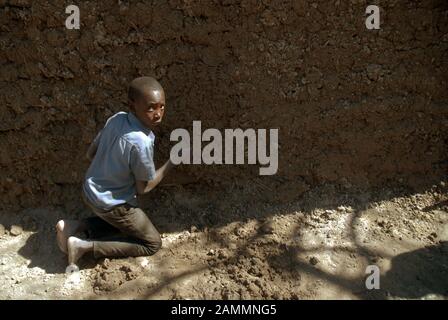 Ragazzo che fa una casa di fango, Mwandi, Zambia, Africa. Foto Stock