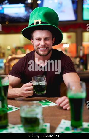 Uomo con cappello e birra di leprechaun che celebra il giorno di San Patrizio Foto Stock