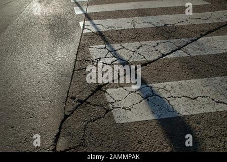 Pedone Crossing su Cracked Road, Siviglia, Spagna. Foto Stock