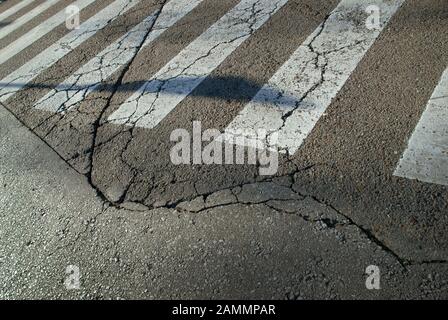 Pedone Crossing su Cracked Road, Siviglia, Spagna. Foto Stock