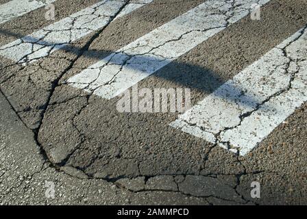 Pedone Crossing su Cracked Road, Siviglia, Spagna. Foto Stock