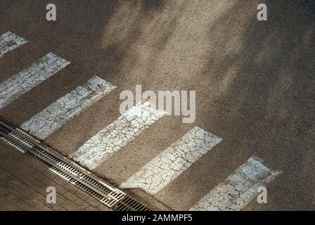 Pedone Crossing su Cracked Road, Siviglia, Spagna. Foto Stock