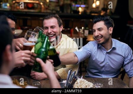 Amici che fanno un brindisi nel pub Foto Stock