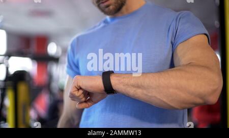 Uomo che controlla la sua applicazione di idoneità dopo l'allenamento per vedere i progressi e i risultati Foto Stock