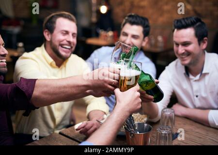 Un gruppo di uomini che fanno un tifo al bar Foto Stock