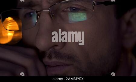 Super primo piano di uomo d'affari volto, uomo in occhiali guardando schermo PC Foto Stock