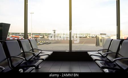 Sala di partenza con posti a sedere vuoti, terminal dell'aeroporto, moderno edificio dei trasporti Foto Stock