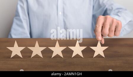 Consumatore mettendo blocchi di legno a cinque stelle sul tavolo Foto Stock
