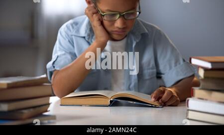 Bambino intelligente lettura mucchio di libri, preparazione per gli esami, homeschooling Foto Stock