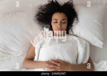 Donna africana che dorme a letto vicino vista dall'alto Foto Stock
