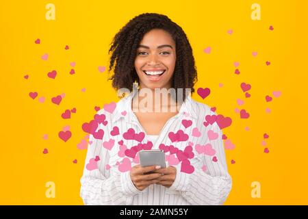 Felice afro ragazza entusiasta di amore messaggi di testo Foto Stock