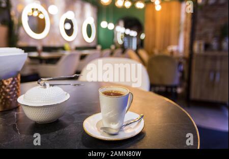 Una tazza di caffe' sul tavolo nell'interno di un moderno cafe' o ristorante Foto Stock