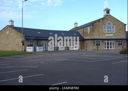 Il parcheggio auto a Banny's British Kitchen (Fish & Chip Shop) al di fuori del confine Mills Shopping al dettaglio in uscita Colne, Pendle, Lancashire, Inghilterra, Regno Unito. Foto Stock