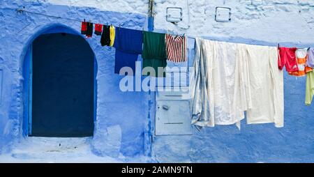 Lavaggio on line contro pareti dipinte di blu, Chefchaouen, Marocco, Nord Africa Foto Stock