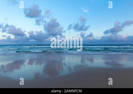 Australia, Yamba, nuovo Galles del Sud, Pippi Beach, nuvole riflesse nel surf Foto Stock