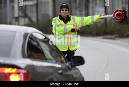 14 gennaio 2020, Mecklenburg-Pomerania occidentale, Rostock: Durante un controllo di polizia, un ufficiale di polizia sconda un veicolo fuori. A Rostock si svolge uno dei numerosi controlli prioritari a livello statale sul tema "traffico stradale". I controlli fanno parte della campagna "Drive.Arrive.Live!". Foto: Bernd Wüstneck/dpa-Zentralbild/ZB Foto Stock