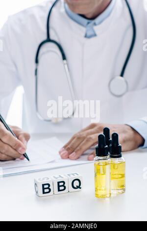 fuoco selettivo di olio di cannabis e cubi con barbeque lettering Foto Stock