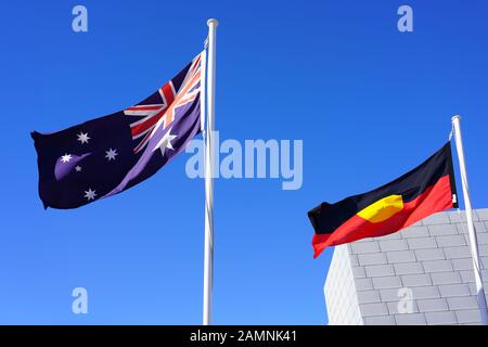 Denham, AUSTRALIA - 7 LUGLIO 2019 - Vista di una bandiera australiana e di una bandiera aborigena che volano fianco a fianco a Denham, Shark Bay, Australia Occidentale. Foto Stock