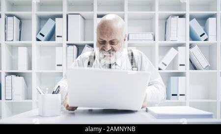 Arrabbiato stressato uomo d'affari maturo rompere il suo portatile, lui sta avendo problemi con il suo computer Foto Stock