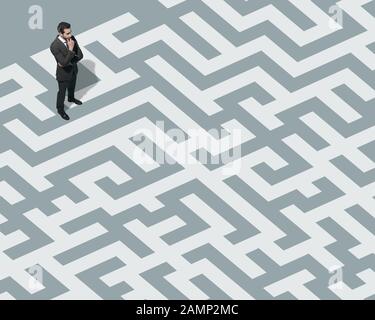 L'uomo d'affari sta in piedi su un labirinto e sta cercando una via d'uscita, una soluzione ed un concetto di strategia di affari Foto Stock