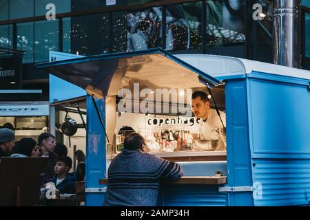 Londra, Regno Unito - 29 dicembre 2019: Donna che acquista cibo da Sud Italia Pizza Stall all'interno di Spitalfields Market, uno dei migliori mercati vittoriani a Londo Foto Stock