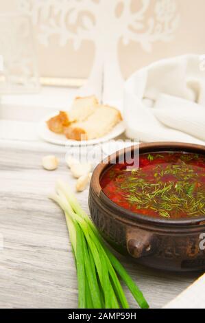 Borsch ucraino con cipolle verdi, pane e aglio. Cibo nazionale Foto Stock